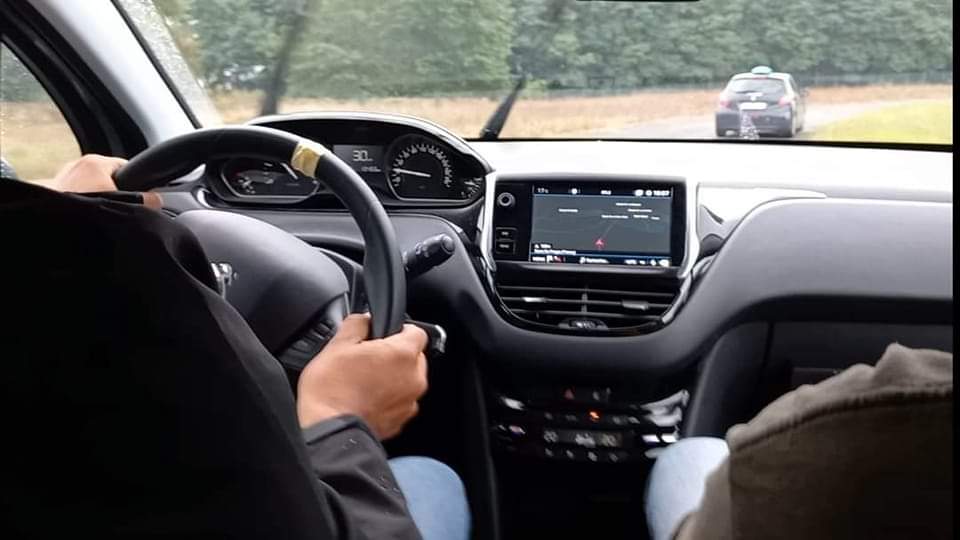 illustration-journée-conduite vu intérieur d'une peugeot 207. Ou l'on voit le volant muni d'un repère de centrage. Le conducteur qui est accompagné d'un moniteur ce trouve sur un circuit.